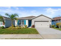 Single-story home with teal accents and landscaping at 3257 Carpentaria Dr, New Smyrna Beach, FL 32168