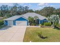 Blue house with metal roof, three-car garage, and landscaped yard at 610 Renner Rd, Port Orange, FL 32127