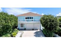 Two-story light blue house with white trim, two-car garage, and balcony at 6345 River Rd, New Smyrna Beach, FL 32169