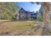 Rustic log cabin home nestled on a spacious lot with mature trees at 735 S Glencoe Rd, New Smyrna Beach, FL 32168