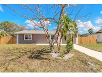 Charming single-story home featuring neutral stucco, white trim, and a tidy front yard with simple landscaping at 1935 Fern Palm Dr, Edgewater, FL 32141