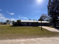 Charming single-story home with a metal roof, lush lawn, and a long private driveway at 2404 Victory Palm Dr, Edgewater, FL 32141