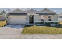 Charming single-story home features a well-manicured lawn, inviting entrance, and two-car garage at 301 Sunset Point Dr, Ormond Beach, FL 32174