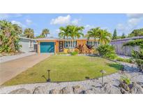 Charming home with a well-manicured front lawn, complemented by lush landscaping and vibrant tropical plants at 308 Normandy Ave, New Smyrna Beach, FL 32169