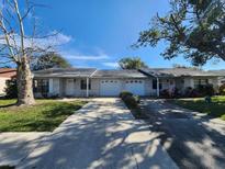 Charming single-story home featuring a well-manicured lawn and attached one car garage at 309 & 311 Sea Hawk Ct, Edgewater, FL 32141