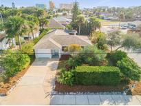 Charming single-story home featuring a well-manicured lawn, mature landscaping, and a concrete driveway at 601 N Peninsula Ave, New Smyrna Beach, FL 32169