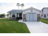 Lovely single-story home showcasing a well-manicured lawn, charming flower boxes, and an attached garage at 848 Pine Shores Cir, New Smyrna Beach, FL 32168