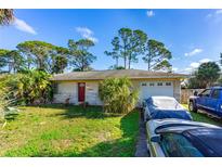 Charming single-story home featuring a well-maintained lawn and a red front door at 1043 Beulah Dr, Edgewater, FL 32132