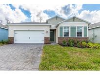 Charming one-story home featuring a two-car garage, brick accents, shutters, and a well-manicured lawn at 1731 Red Rock Rd, New Smyrna Beach, FL 32168