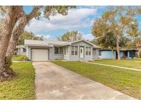 Charming single-story home featuring a well-maintained lawn, metal roof and an attached one car garage at 254 Tanner St, New Smyrna Beach, FL 32168