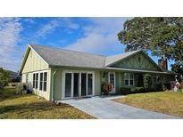 Charming single-story home with a well-manicured lawn, sliding door access, and a classic look at 26 Birdie Dr, New Smyrna Beach, FL 32168