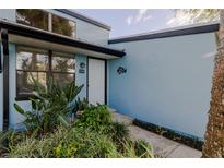 Charming front entrance featuring lush landscaping and light blue exterior paint at 43 Jacaranda Cay Ct # 430, New Smyrna Beach, FL 32169