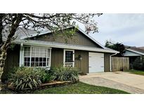 Charming home featuring a well-maintained lawn, a bay window, and an attached one-car garage at 45 Sandra Cir, New Smyrna Beach, FL 32168