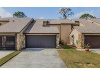 Charming townhome featuring a two-car garage, stone accents, and well-maintained landscaping at 456 Shorewood Ln, New Smyrna Beach, FL 32168