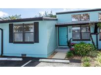 Charming exterior view of a light blue condo with black shutters and a well-maintained front entrance at 47 Jacaranda Cay Ct # 470, New Smyrna Beach, FL 32169