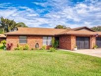 Charming single-story brick home featuring a well-maintained lawn and attached two-car garage at 1818 Enterprise Ave # B, New Smyrna Beach, FL 32168