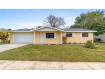 Charming single-story home with a well-manicured lawn and attached two car garage at 2211 Brian Ave, South Daytona, FL 32119