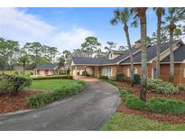 Charming brick home with a long driveway, mature trees, and beautifully landscaped front yard at 2333 Southern Pines Pl, Deland, FL 32724