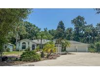 Charming single-story home with lush landscaping, mature trees, and an attached two-car garage at 2576 Shilo Glynn Ln, New Smyrna Beach, FL 32168