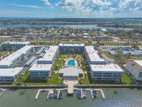 Stunning aerial view of waterfront condo complex with pool, boat docks, and bay views at 315 N Causeway # C402, New Smyrna Beach, FL 32169