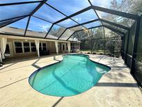 Outdoor screened in pool with patio furniture and blue water at 3435 Black Willow Trl, Deland, FL 32724