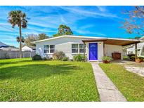 Charming single-story home featuring a bright blue front door and well-maintained lawn at 902 Conrad Dr, New Smyrna Beach, FL 32168