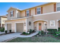 Charming townhome with tan siding, brown shutters, well manicured lawn, and an inviting front entryway at 94 Bella Vita Way, Ormond Beach, FL 32174