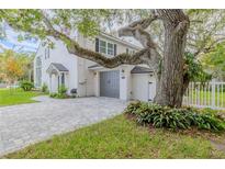 Charming two-story white home with gray accents, a driveway, and mature landscaping at 111 Esther St, New Smyrna Beach, FL 32169