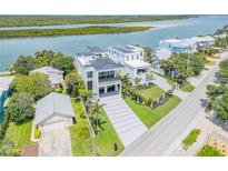 Gorgeous waterfront home with an elegant exterior, lush landscaping, and spacious driveway at 1194 N Peninsula, New Smyrna Beach, FL 32169