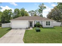 Charming single-story home with a well-manicured lawn, fresh landscaping and a white two-car garage at 1290 9Th St, Orange City, FL 32763