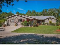 Charming brick home with a well-manicured lawn and colorful landscaping at 1370 Jane Lacey Ln, New Smyrna Beach, FL 32168