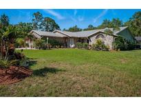 Charming single-story brick home featuring a metal roof, manicured lawn and beautifully landscaped flowerbeds at 1370 Jane Lacey Ln, New Smyrna Beach, FL 32168