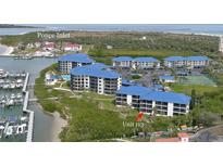 Aerial view of waterfront condos with blue roofs, marina, and ocean view in Ponce Inlet at 2700 N Peninsula Ave # 113, New Smyrna Beach, FL 32169