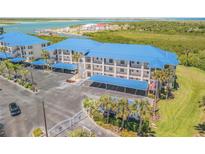 Beautiful three-story condo complex features a blue metal roof, covered parking, and waterfront views at 2700 N Peninsula Ave # 513, New Smyrna Beach, FL 32169