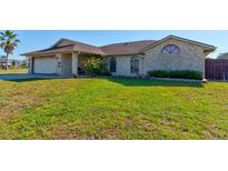 Charming brick home with a well-manicured lawn and inviting curb appeal in a sunny neighborhood at 3163 Dudley Dr, Deltona, FL 32738