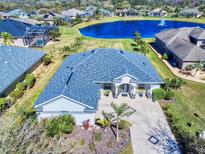 Stunning aerial view of the home showcasing its well-maintained landscaping, lakeside views, and charming curb appeal at 3611 Marisol Ct, New Smyrna Beach, FL 32168