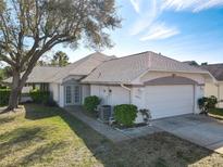 Charming single-story home featuring a well-manicured lawn, mature tree, and a two-car garage at 4583 Barnacle Dr, Port Orange, FL 32127