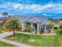Beautiful single-story home featuring mature palms, landscaping, manicured lawn and a paver driveway at 6665 Merryvale Ln, Port Orange, FL 32128
