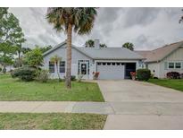 Charming single-story home with a manicured lawn, gray siding and white painted brickwork details at 731 Pine Shores Cir, New Smyrna Beach, FL 32168