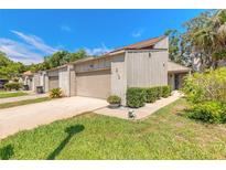 Charming townhome with a well-manicured lawn, lush landscaping, and private driveway at 210 Pine Cone Trl, Ormond Beach, FL 32174