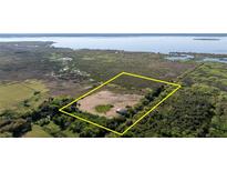 Expansive land lot with a framed boundary, surrounded by trees and wetlands, and a view of the serene lake at 3890 Skyway Dr, Sanford, FL 32773