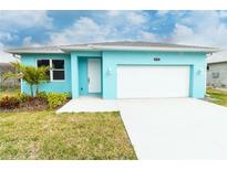 Charming turquoise single-story home with a white garage door, landscaped yard, and a well-lit front entrance at 113 Douglas St, Edgewater, FL 32141