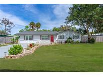 Charming home with well-manicured lawn, stone accents, and a vibrant red front door at 2809 Lime Tree Dr, Edgewater, FL 32141