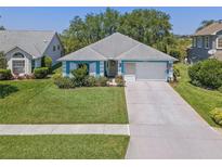 Charming one-story home with well-manicured lawn, mature landscaping and light blue exterior at 1363 Wayne Ave, New Smyrna Beach, FL 32168