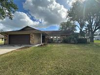 Charming single-story home with a well-maintained lawn and stone accents on the facade at 1629 Travelers Palm Dr, Edgewater, FL 32132