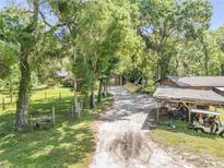 Charming home exterior with a long driveway and a lush, tree-filled yard, creating a private setting at 1663 Hideaway Ln, Edgewater, FL 32132
