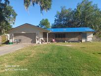 Single-story home featuring a two-car garage, a spacious lawn, and a covered front porch at 168 N Cory Dr, Edgewater, FL 32141