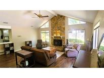 Inviting living room featuring a stone fireplace, wood floors, and bright natural light at 171 Fox Glen Ct, Ormond Beach, FL 32174