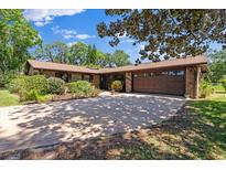 Charming single-story brick home featuring an attached two-car garage and beautiful landscaping at 1905 Pine Tree Dr, Edgewater, FL 32141