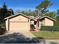 Charming single-story home featuring a two-car garage, well-maintained lawn, and beautiful landscaping at 1918 Whisperwood Way # 10, Port Orange, FL 32128